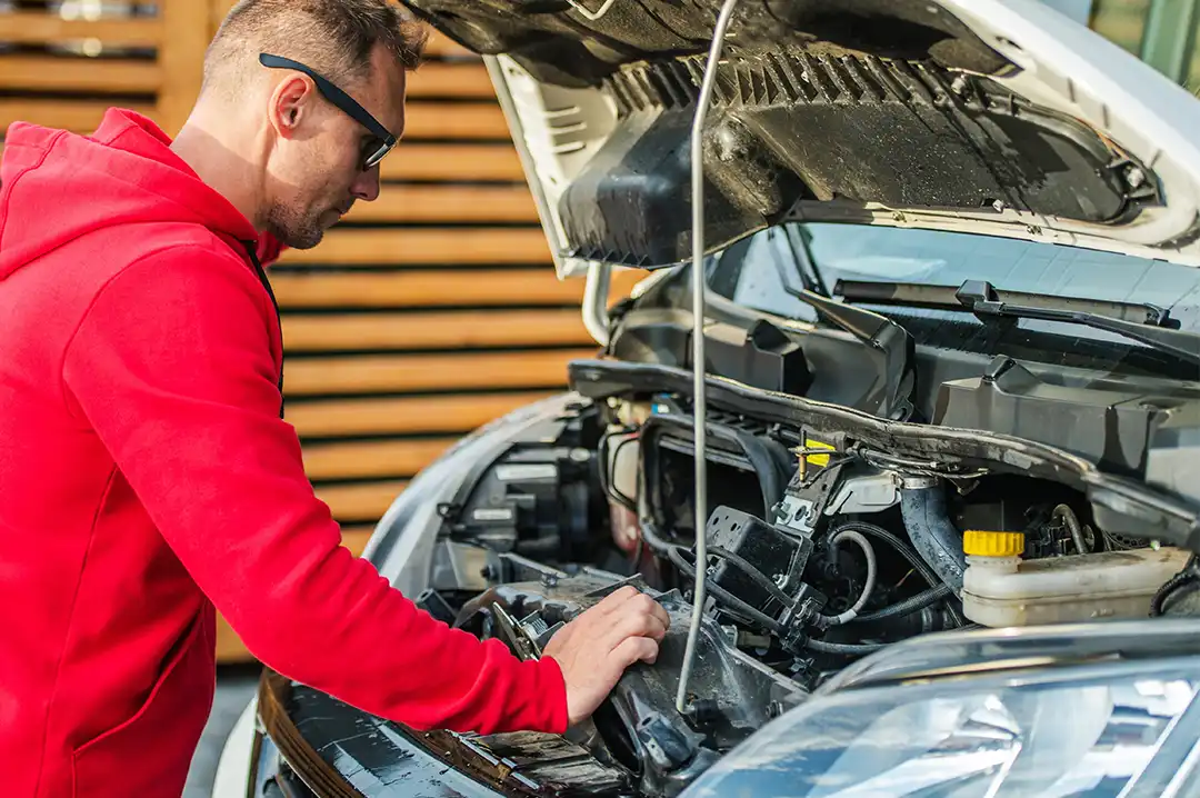 Ein Mann begutachtet den Motor eines Wohnmobils.
